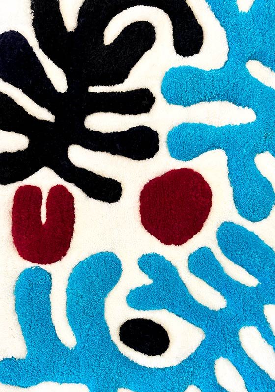 Taftintas kilimas su juodais, mėlynais ir raudonais grafiniais elementais